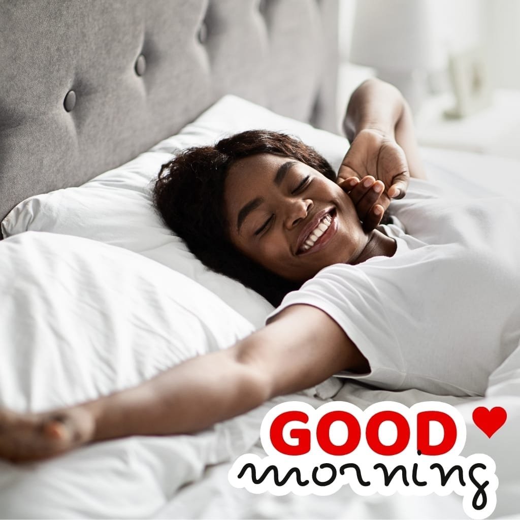 100+ African American Good Morning Images – Inspirational & Positive Vibes 2025 31 A beautiful woman woke up smiling in the early morning on the bed in front of sunlight.